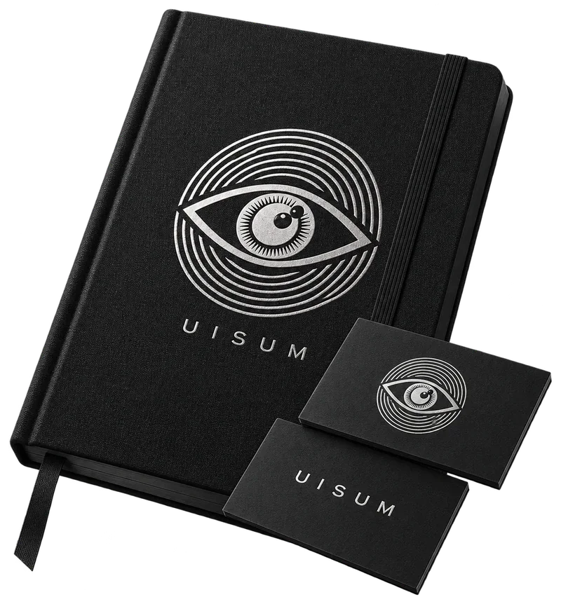 Notizbuch mit silbern geprägtem Uisum-Auge, davor zwei Visitenkarten